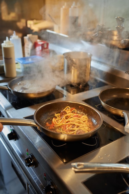 Chef está mexendo legumes no wok no conceito de comida de rua