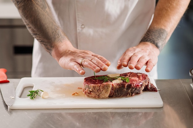 Chef está preparando un bistec para freír en la cocina del restaurante