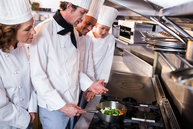 Chef experiente, explicando aos colegas na cozinha