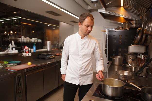 Chef experiente trabalhando em seu restaurante, cozinhando na cozinha