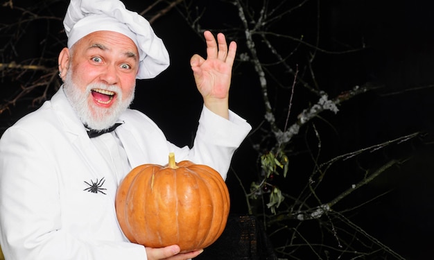 Chef feliz con calabaza muestra signo bien. Calabaza fresca. Vitamina estacional. Mercado agrícola. Cocina del día de acción de gracias.