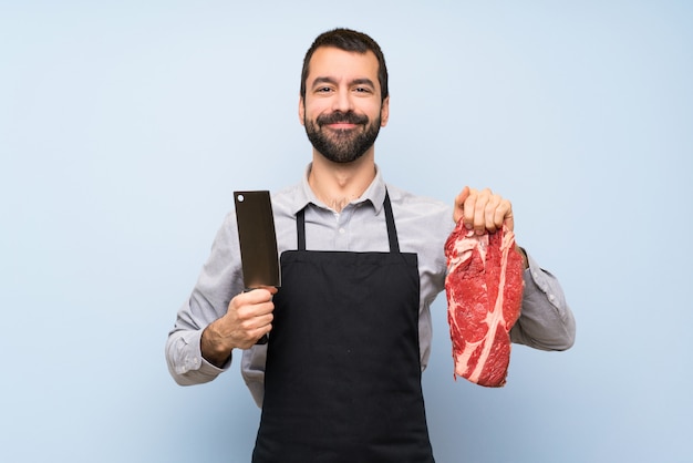 Foto chef feliz sosteniendo una carne cruda