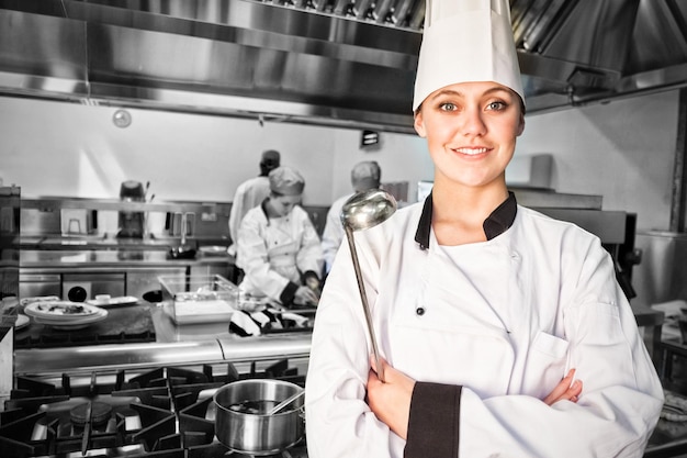 Chef femenina con cucharón en cocina comercial