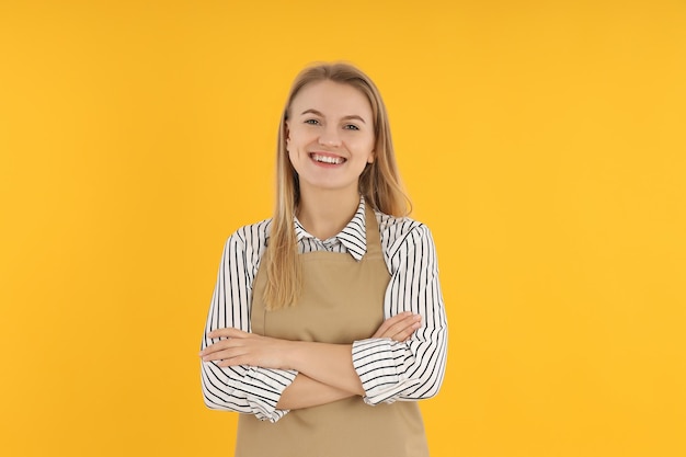 Chef femenina en delantal sobre fondo amarillo