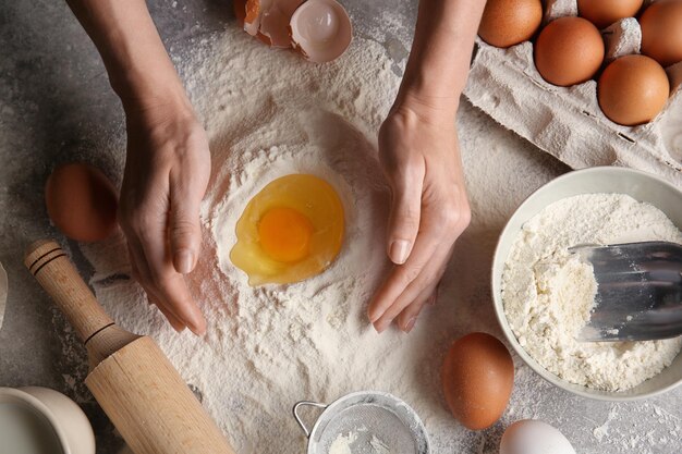 Chef femenina haciendo masa en la mesa de la cocina