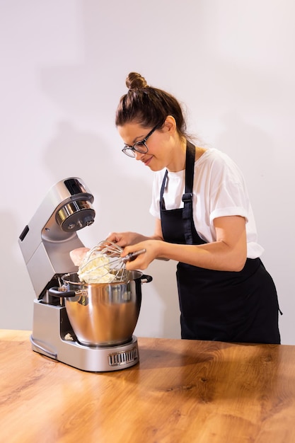 Chef femenina profesional cocinando comida en una cocina grande y divirtiéndose