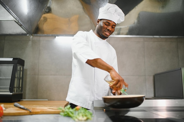Chef gourmet en uniforme cocinando en una cocina comercial