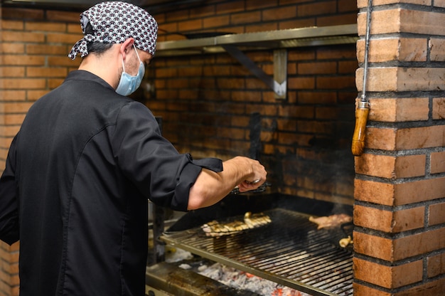 Chef grelhando bifes em cozinha comercial