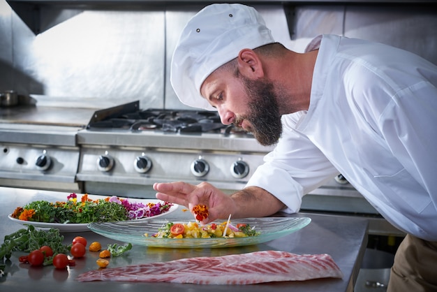 Chef guarnición de flores en plato de ceviche