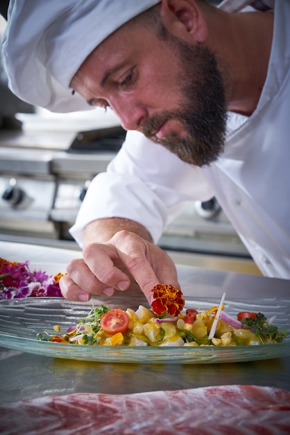 Foto chef guarnición de flores en plato de ceviche