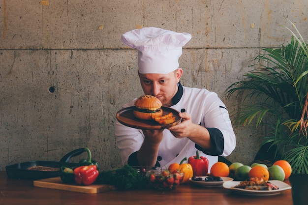 Chef haciendo hamburguesa de pollo en la cocina.