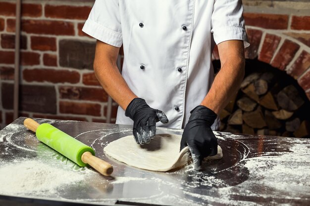 Chef haciendo masa para pizza Manos de hombre preparando pan Concepto de horneado y pastelería