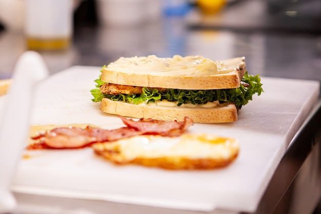 Chef haciendo sándwich con ingredientes frescos deliciosa nutrición.