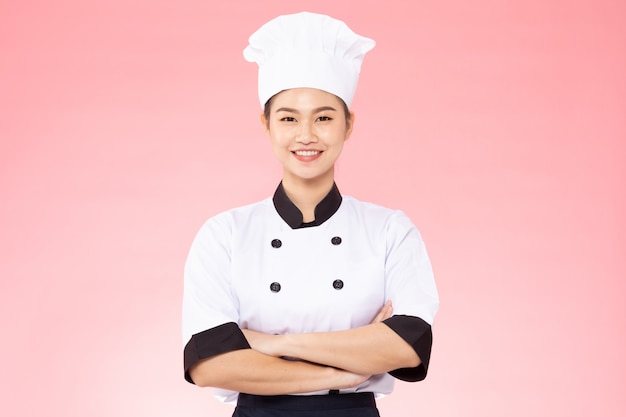Chef hermosa mujer sonríe sobre fondo rosa