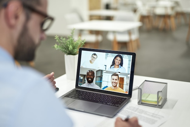 Chef hört den Mitarbeitern beim Online-Meeting zu