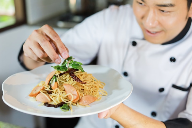 Chef hombre asiático cocinando comida en restaurante