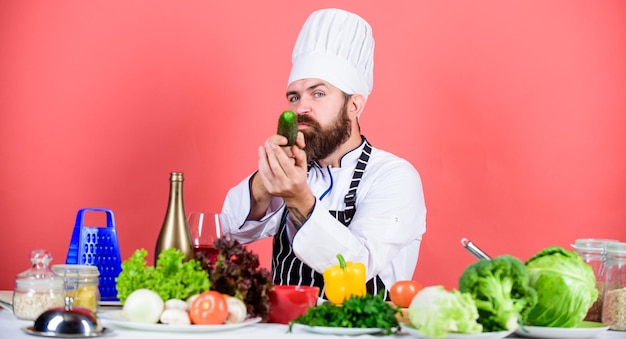 Chef homem de chapéu Receita de sabor secreto Dieta e comida orgânica vitamina Vegetariana Dieta pouco saudável Chef maduro com barba Homem barbudo cozinhar na cozinha culinária Cozinhar comida saudável