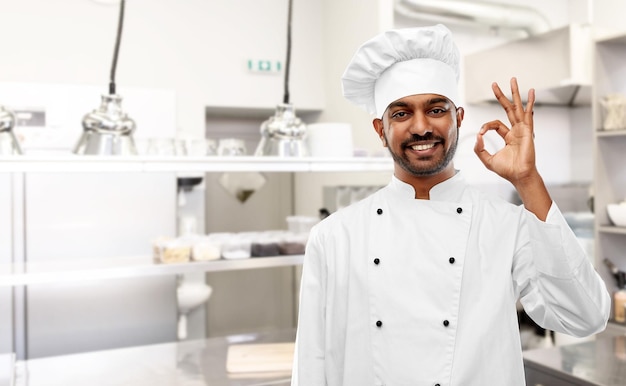 Foto chef indiano mostrando sinal ok na cozinha do restaurante