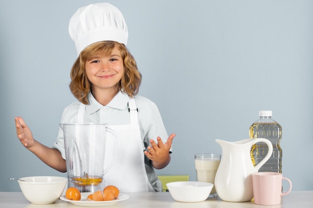 Chef infantil vestido con delantal de panadero y gorro de chef aislado en el fondo del estudio nutrición saludable