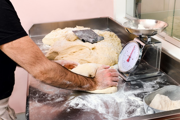 Chef knetet eine Menge frischen Pizzateig