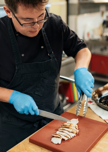 Chef macho cortando carne en la cocina