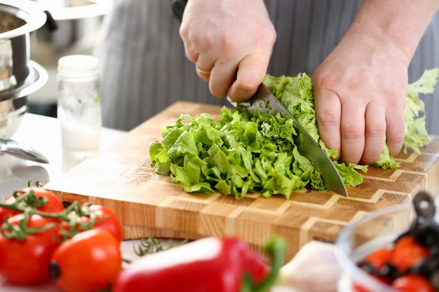 Chef manos cortando lechuga fresca verde ingrediente