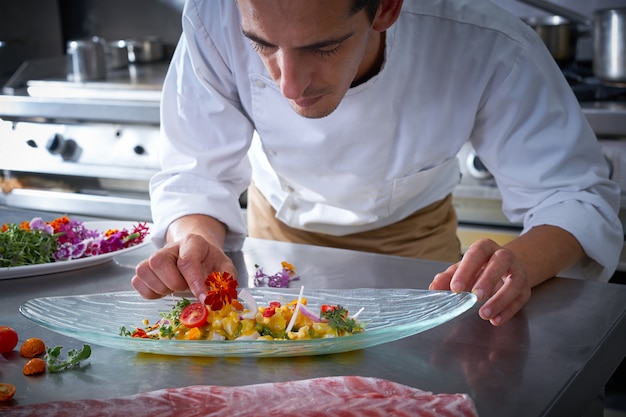 Chef manos guarnición de plato de verduras