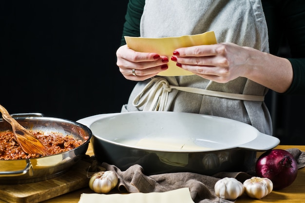 Chef manos haciendo una lasaña