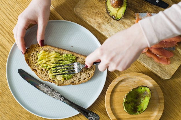 Chef de mantequilla de aguacate sobre pan negro tostado.