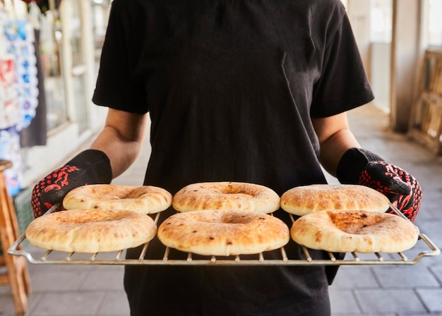 Chef mantiene la pita en la rejilla de alambre después de ser horneada en el horno eléctrico