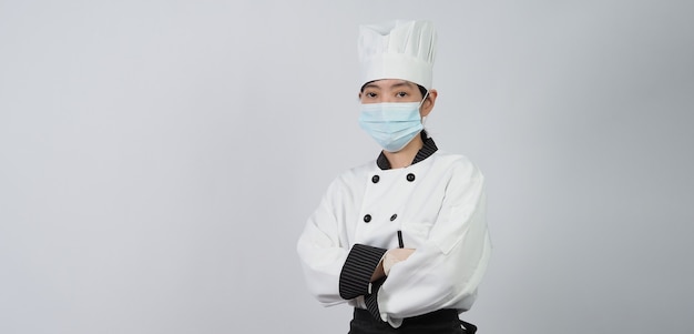 Chef con máscara médica protectora facial o respirador para protegerse de las enfermedades virales. Seguridad alimentaria y pandemia de coronavirus. chef posando gesto representan pedidos en línea. sanidad alimentaria.