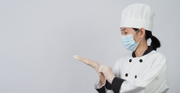 Chef con máscara médica protectora facial o respirador para protegerse de las enfermedades virales. Seguridad alimentaria y pandemia de coronavirus. chef posando gesto representan pedidos en línea. sanidad alimentaria.