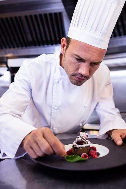 Chef masculino adornando el plato de postre