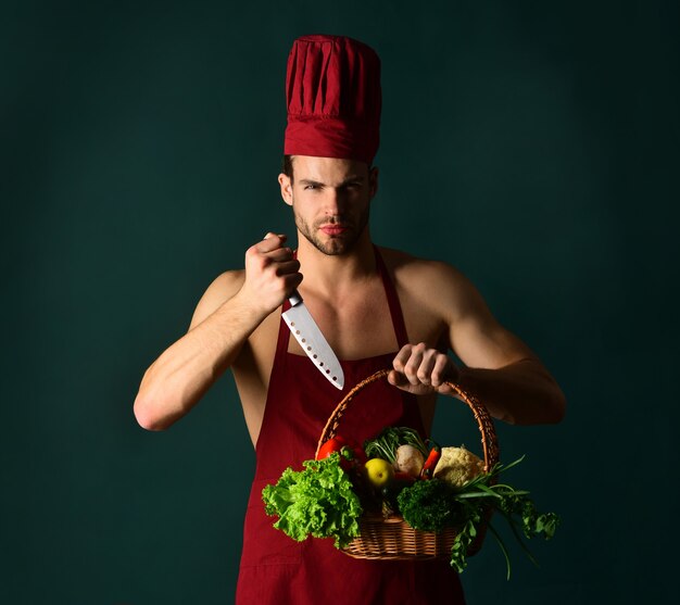 Chef masculino barbudo segura uma cesta com legumes e faca conceito profissional de preparação de alimentos, homem