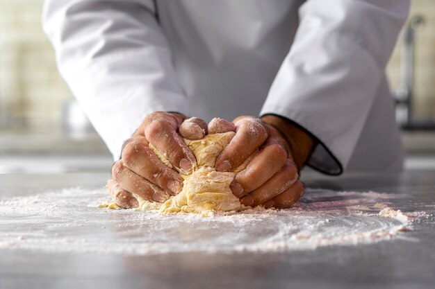 Foto chef masculino en la cocina amasando masa