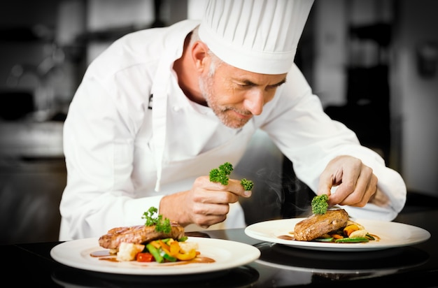 Foto chef masculino concentrado decorando comida na cozinha