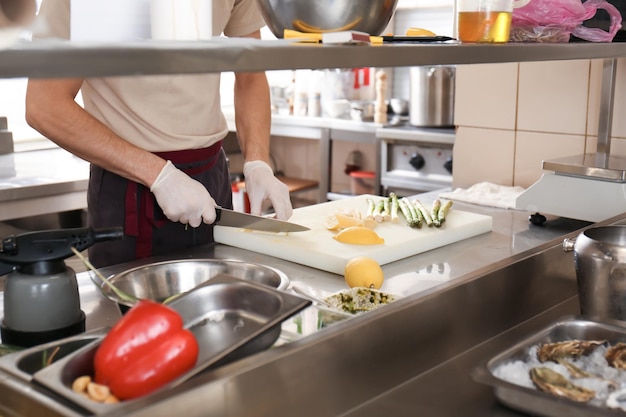 Foto chef masculino cortando limón en la cocina del restaurante