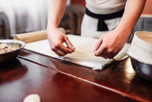 Chef masculino cozinhar strudel de maçã na cozinha. Sobremesa doce caseira, processo de preparação