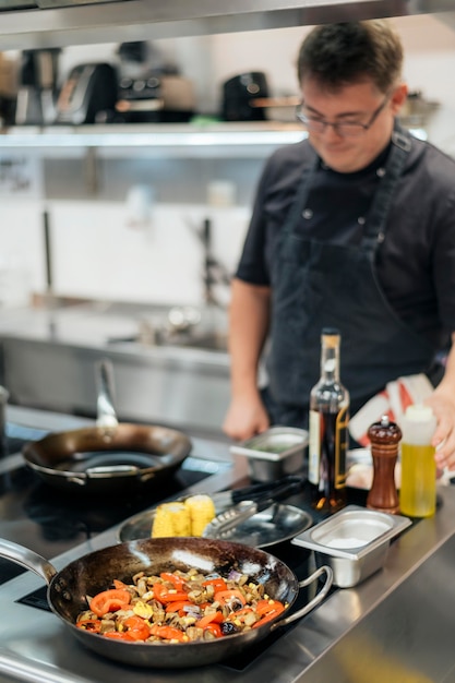 Foto chef masculino desfocado cozinhando na cozinha