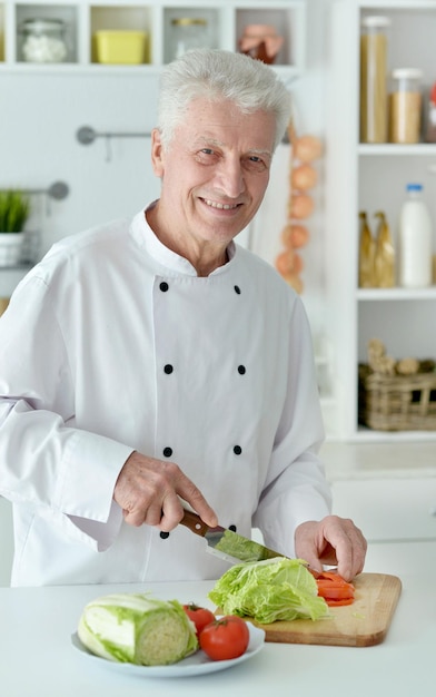 Chef masculino idoso cozinhando salada