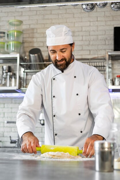 Foto chef masculino na cozinha rolando massa