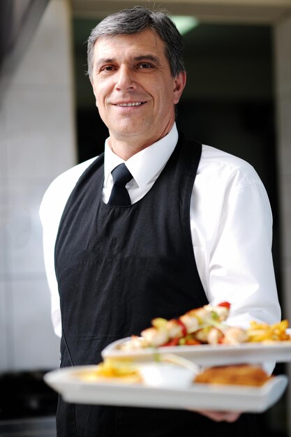 Foto chef masculino presentando comida en la cocina