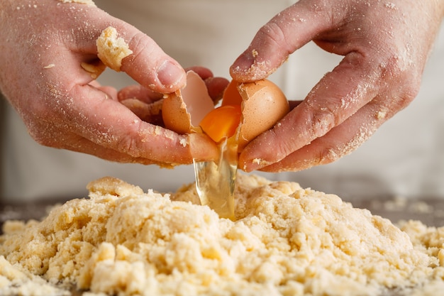 Chef masculino se prepara. Homem mistura bata os ovos. Vista do topo