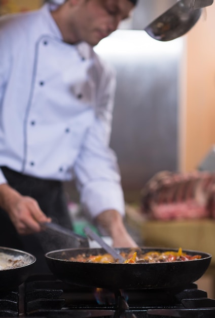 Chef master preparando a comida, fritando na frigideira wok. Venda e conceito de comida