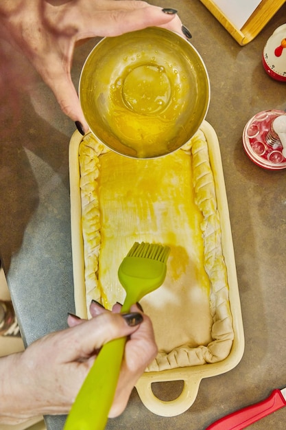 Chef mergulha um ovo em suflê feito de batata francesa, abobrinha, couve-flor e queijo amarelo