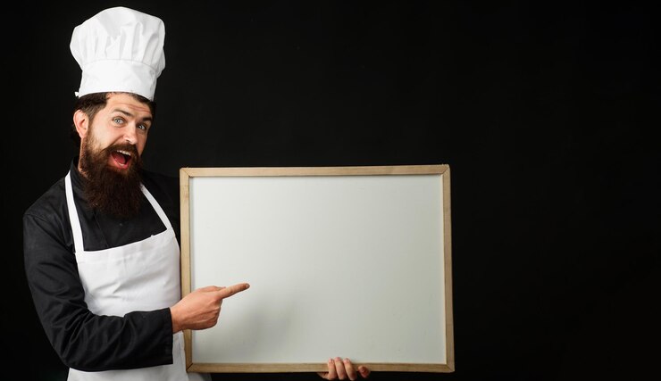Foto chef mostrando placa de sinal de menu vazio com espaço de cópia para publicidade de restaurante de serviço de comida de texto
