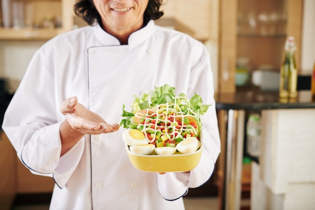 Chef mostrando sabrosa ensalada