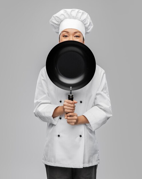 chef mujer asomando desde detrás de la sartén