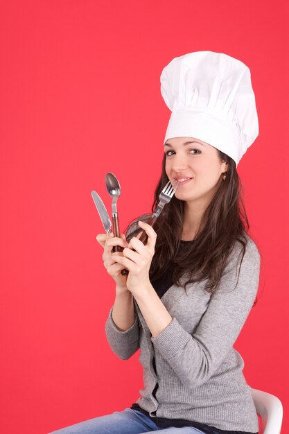 Chef mujer con cubiertos en sus manos