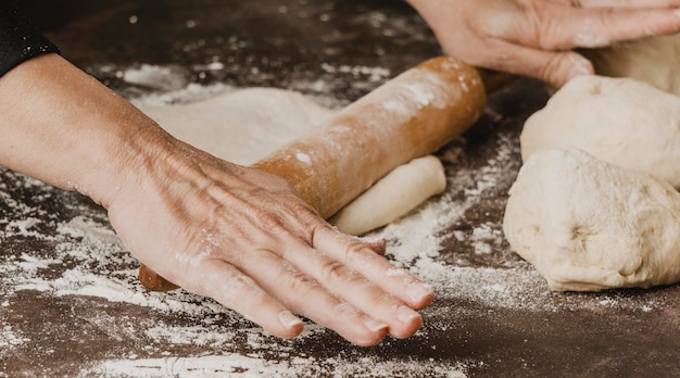 Foto chef mujer rodando masa de pizza sobre la mesa